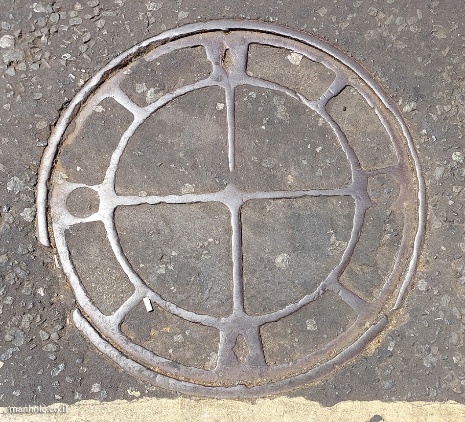 London - an old round concrete cover with metal strips and an outer ring