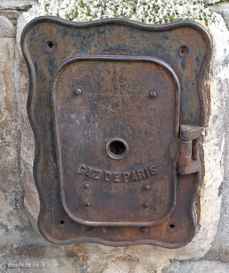 Paris - a gas cover that is on a wall and not on the ground