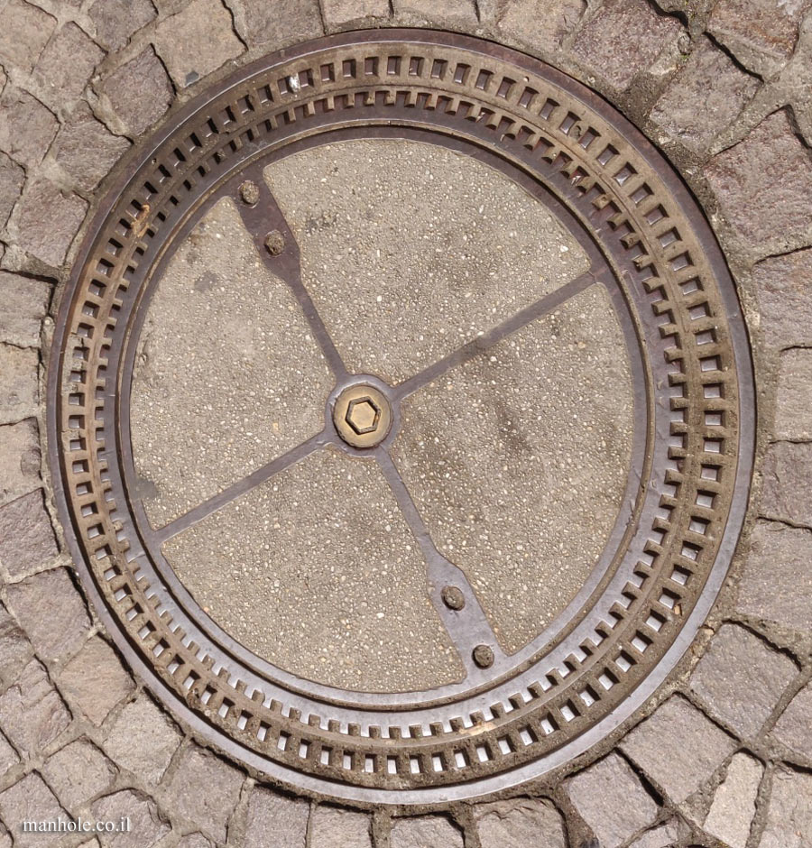 Frankfurt - concrete cover divided by metal strips and surrounded by a round metal frame